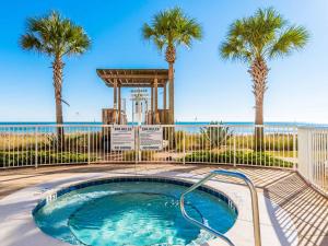 a swimming pool with palm trees and a gazebo at Sandy Key #223 in Perdido Key