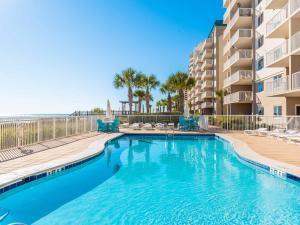 a swimming pool with chairs and a building at Sandy Key #223 in Perdido Key