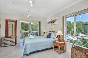 a bedroom with a bed and windows at Golden Sands Beachfront Resort in Yorkeys Knob