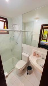 een badkamer met een toilet, een douche en een wastafel bij Casa Peixinho - Reserva Imbassaí 3 suítes in Imbassai