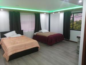 two beds in a room with green lights at Casa de Campo El Cabañal - San José De Minas in Quito