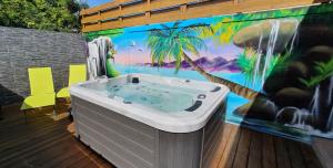 a hot tub on a deck with a mural at "Chez Claudia "charmant logement avec jacuzzi privatif en toute intimité sur belle terrasse extérieure en bois et piscine in Courcelles Sucrerie