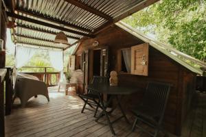 a room with a table and chairs on a deck at Hacienda Tres Casitas in Cabo Rojo