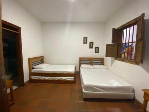 a room with two beds and a window at Hotel Trujillo Plaza in Trujillo