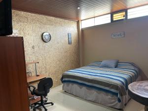 a bedroom with a bed and a desk and a sink at HuehueLoft1 estacionamiento y wifi in Huehuetenango