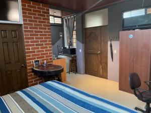 a bedroom with a bed and a table and a kitchen at HuehueLoft1 estacionamiento y wifi in Huehuetenango