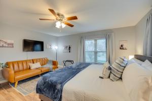 a bedroom with a bed and a couch and a ceiling fan at Modern and Spacious Apartment Minutes to FW and Stockyards in Fort Worth