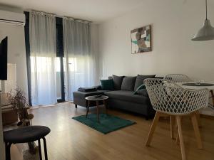 un soggiorno con divano, tavolo e sedie di Apartment IRIS a Novi Sad