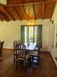 comedor con mesa de madera y sillas en Cabaña en los Acantilados en Mar del Plata