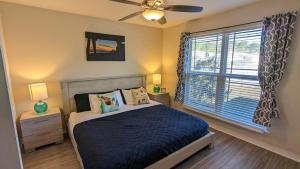 sypialnia z łóżkiem z wentylatorem sufitowym i oknem w obiekcie Beachy Bliss the perfect stay w mieście Navarre