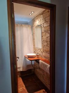 Un baño con lavabo y pared de piedra. en Cabaña en los Acantilados, en Mar del Plata