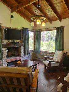 Una sala de estar con chimenea y televisión. en Cabaña en los Acantilados, en Mar del Plata