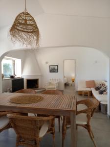 uma sala de estar com uma mesa de madeira e cadeiras em Tasi Ingrina em Vila do Bispo