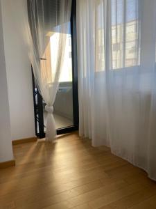 Pokój z oknem z lampką i drewnianą podłogą w obiekcie Apartment IRIS w Nowym Sadzie