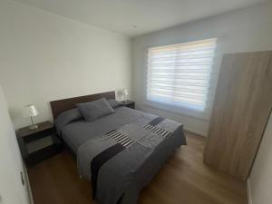 1 dormitorio con cama y ventana en Casa nueva de playa 3D 2B, en El Quisco