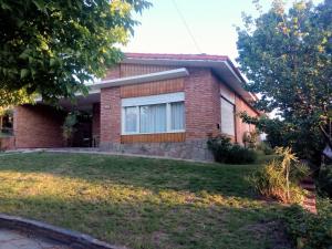 a brick house with a yard in front of it at Casa Monty in Mina Clavero