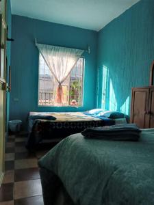 a blue bedroom with two beds and a window at CASA BELINDA in Santiago Atitlán