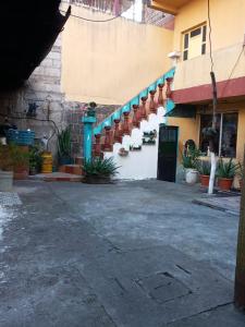 un bâtiment avec un escalier dans une cour ornée de plantes dans l'établissement CASA BELINDA, à Santiago Atitlán