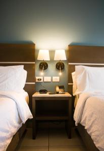 a room with two beds and a table with two lamps at Holiday Inn Express Merida Centro by IHG in Mérida +51 photos