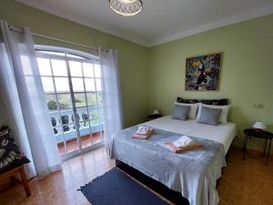 une chambre avec un lit et une grande fenêtre dans l'établissement Villa Margot: grande moradia com piscina, à Olhão