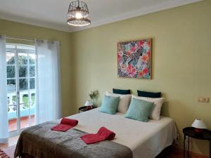- une chambre avec un lit et 2 serviettes rouges dans l'établissement Villa Margot: grande moradia com piscina, à Olhão