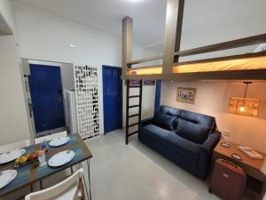 ein Wohnzimmer mit einem Sofa und einem Hochbett in der Unterkunft Estúdio Moderno 70 metros da praia do Embaré ! Pet - Wi-Fi - Ar condicionado! in Santos