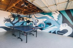 a ping pong table in a room with a mural at Minutes to JT National Park, Hot Tub & Game Room in Joshua Tree