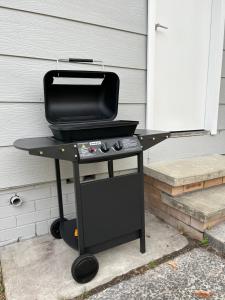 a grill sitting on a table in front of a house at Comfortable 1 bedroom duplex close to everything in Budgewoi