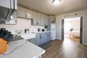 a kitchen with white cabinets and a white refrigerator at Minutes to JT National Park, Hot Tub & Game Room in Joshua Tree