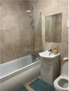 uma casa de banho com uma banheira, um lavatório e um WC. em Modern and Stylish 1bed flat em Barking