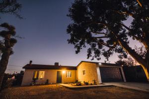 a house with a garage at night at Minutes to JT National Park, Hot Tub & Game Room in Joshua Tree