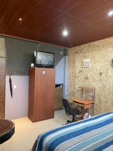 Zimmer mit einem Bett und einem TV an der Wand in der Unterkunft HuehueLoft1 estacionamiento y wifi in Huehuetenango