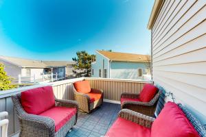 a balcony with three chairs and a fence at Mariners Court - 4 Laurel St Unit 219 in Rehoboth Beach