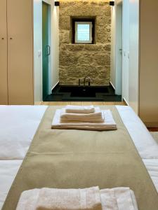 a bathroom with two towels on a bed with a sink at Quinta da Porta - Solar de Vale de Prazeres in Vale de Prazeres