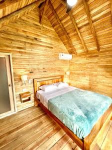 a bedroom with a bed in a wooden room at Hotel Oasis & Surf Camp in Santa Catalina