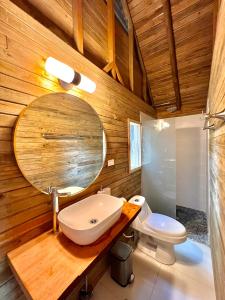 a bathroom with a sink and a mirror and a toilet at Hotel Oasis & Surf Camp in Santa Catalina