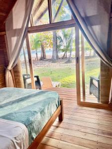 a bedroom with a bed and a large window at Hotel Oasis & Surf Camp in Santa Catalina