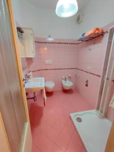 różowa łazienka z umywalką, wanną i toaletą w obiekcie Casa Fontanelle w mieście Celano