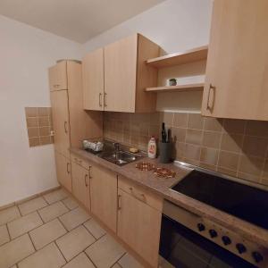 a kitchen with wooden cabinets and a sink and a counter at Selb Ferienwohnungen in Selb +23 photos