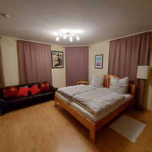 um quarto com uma cama e um sofá em Selb Ferienwohnungen em Selb