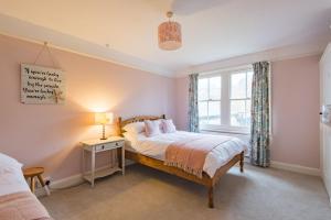Schlafzimmer mit einem Bett und einem Fenster in der Unterkunft Prospect Cottage by Bloom Stays in Hythe
