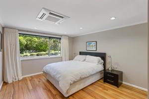 Un dormitorio con una cama grande y una ventana en Slice of Heaven - Napier Holiday Home en Napier