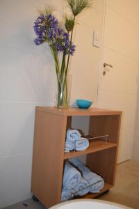 un jarrón de flores en un estante con toallas en Departamento nuevo en Condominio Portezuelo, cerca de todo en Salta