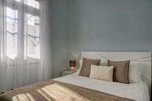 a bedroom with a white bed and a window at Casa do Pinheiro, a Home in Madeira in São Vicente