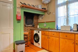 a kitchen with a washing machine and a stove at Casa do Pinheiro, a Home in Madeira in São Vicente