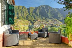 a balcony with chairs and a view of mountains at Casa do Pinheiro, a Home in Madeira in São Vicente