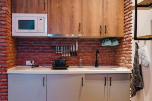 a kitchen with a white sink and a brick wall at New Gudauri, Alpic 503 in Gudauri