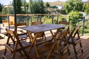 a wooden table and chairs on a deck at Casa de Montaña - Hunuc Huar in Potrerillos