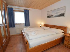 a bedroom with a large bed with a wooden frame at Villa Chapter Two in Niedernsill