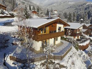 a house covered in snow in the mountains at Villa Chapter Two in Niedernsill